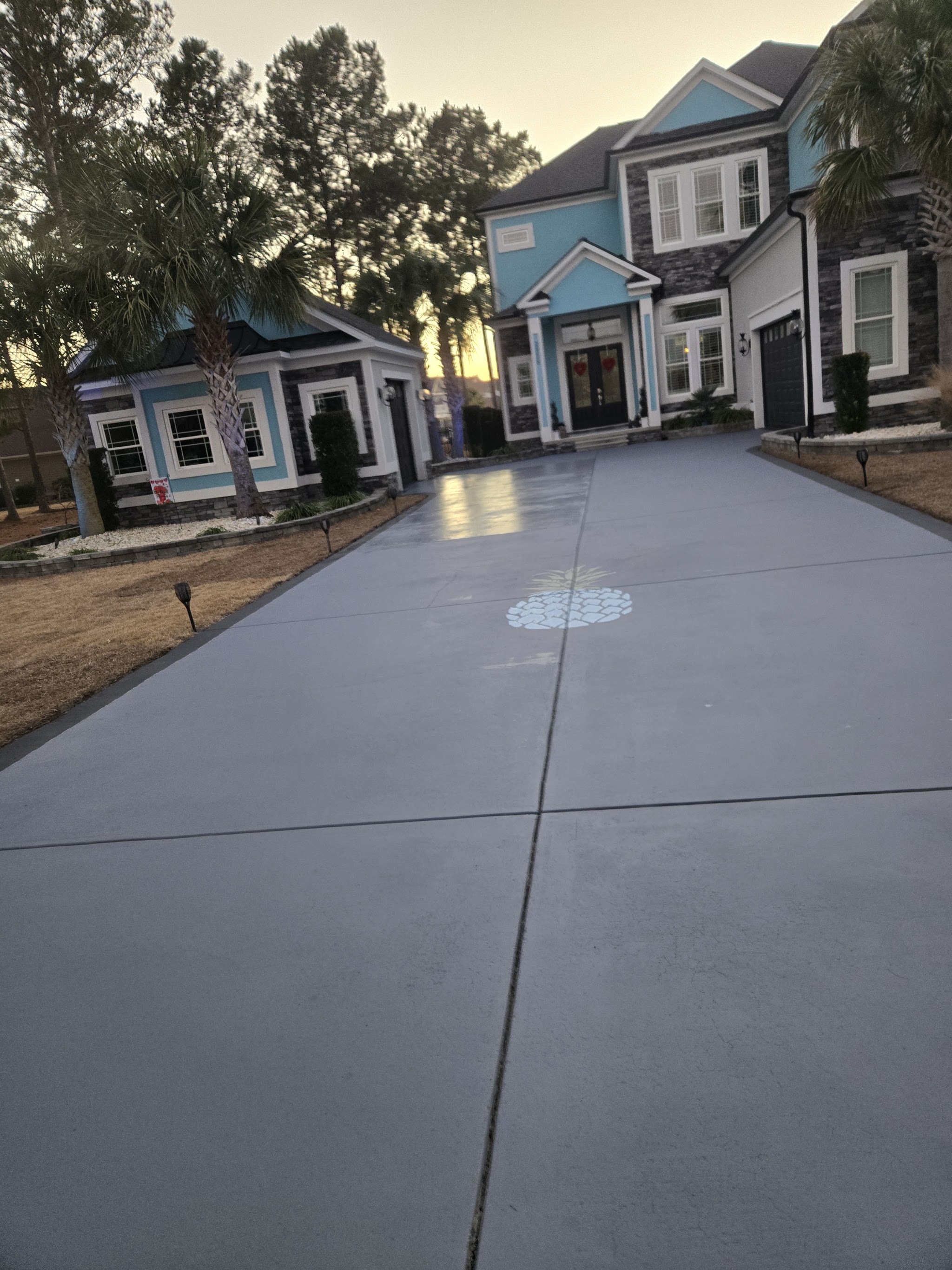 Smooth finished concrete driveway leading to a house